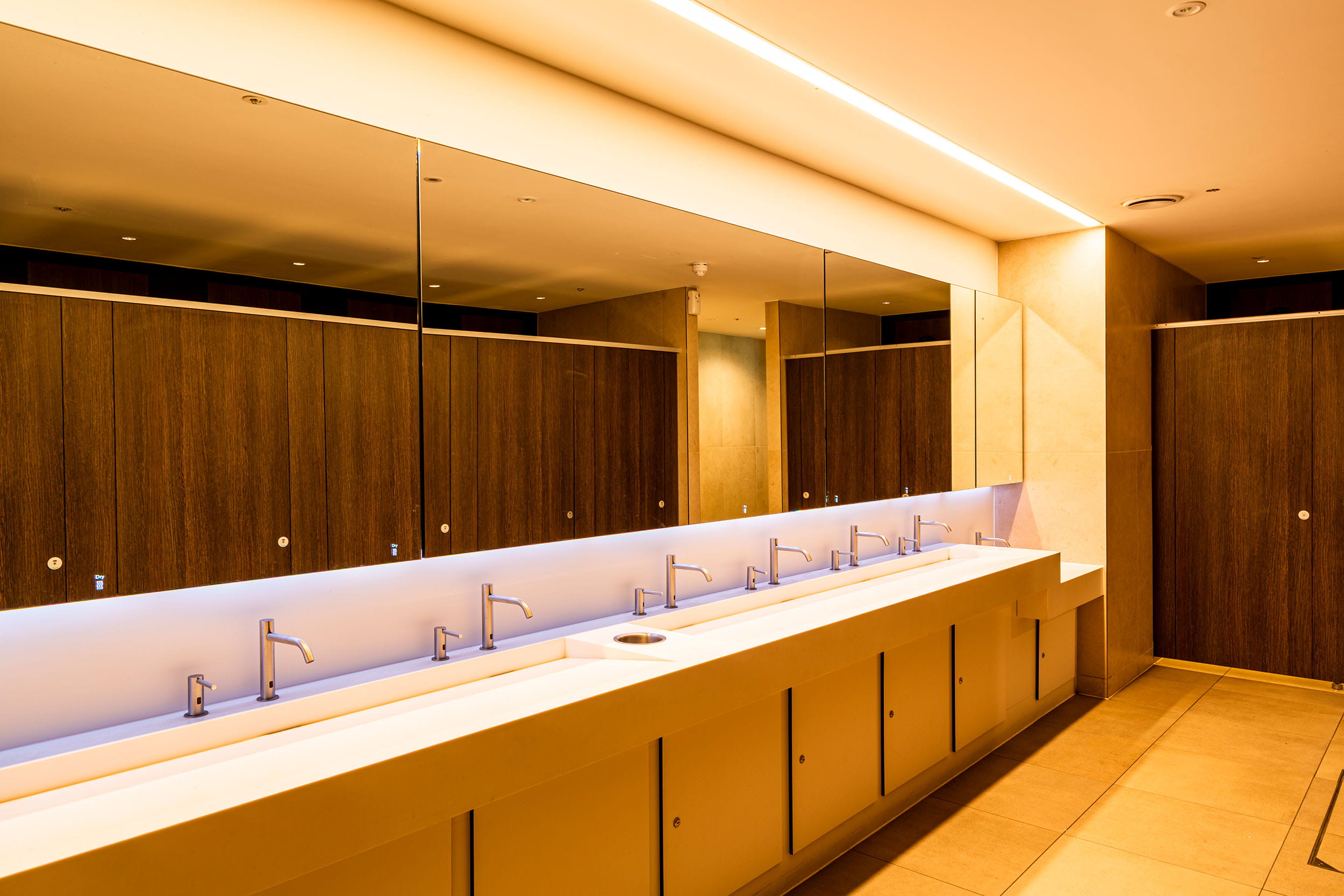 The upgraded public toilet facilities at Palace Gardens, featuring modern sinks, mirrors and warm lighting.